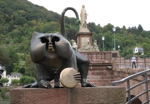 德國的海德堡是傍內(nèi)卡河而建的古老城市。橫跨內(nèi)卡河南北兩岸的古橋是海德堡的標(biāo)志性建筑之一。橋的西邊有一只拿著鏡子的猴子雕像。在海德堡有這樣的說法,摸一摸猴子手里的銅鏡就會(huì)帶來財(cái)富,摸一摸猴子右手向外指的手指代表會(huì)再回到海德堡。銅鏡子已經(jīng)被游客們摸得锃光瓦亮了。