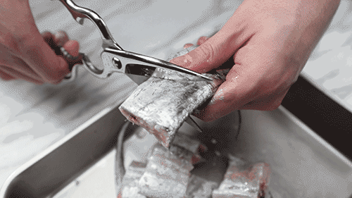 帶魚清洗:解凍、剪去頭部和魚鰭,剪開魚肚切段,掏內臟用水洗凈